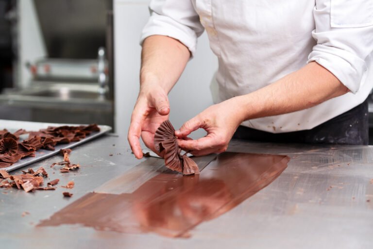 Professional confectioner making chocolate sweets at confectionery shop